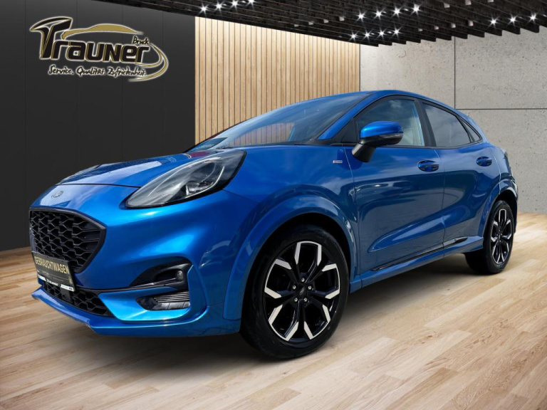 Blauer Ford Puma in einem Autohaus, schräg von vorn auf hellem Holzboden fotografiert