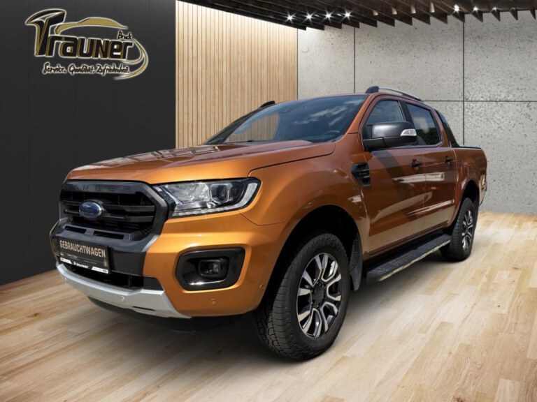 Oranger Ford Ranger Wildtrak Doppelkabinen-Pick-up in einem Ausstellungsraum, von vorn links