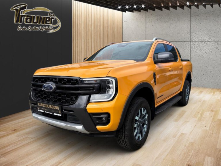 Oranger Ford Ranger Wildtrak mit Doppelkabine in einem modernen Ausstellungsraum, Ansicht von vorn links
